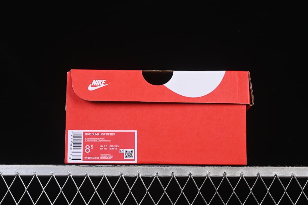 Red shoe box with label identifying Nike Dunk Low Retro and sample size