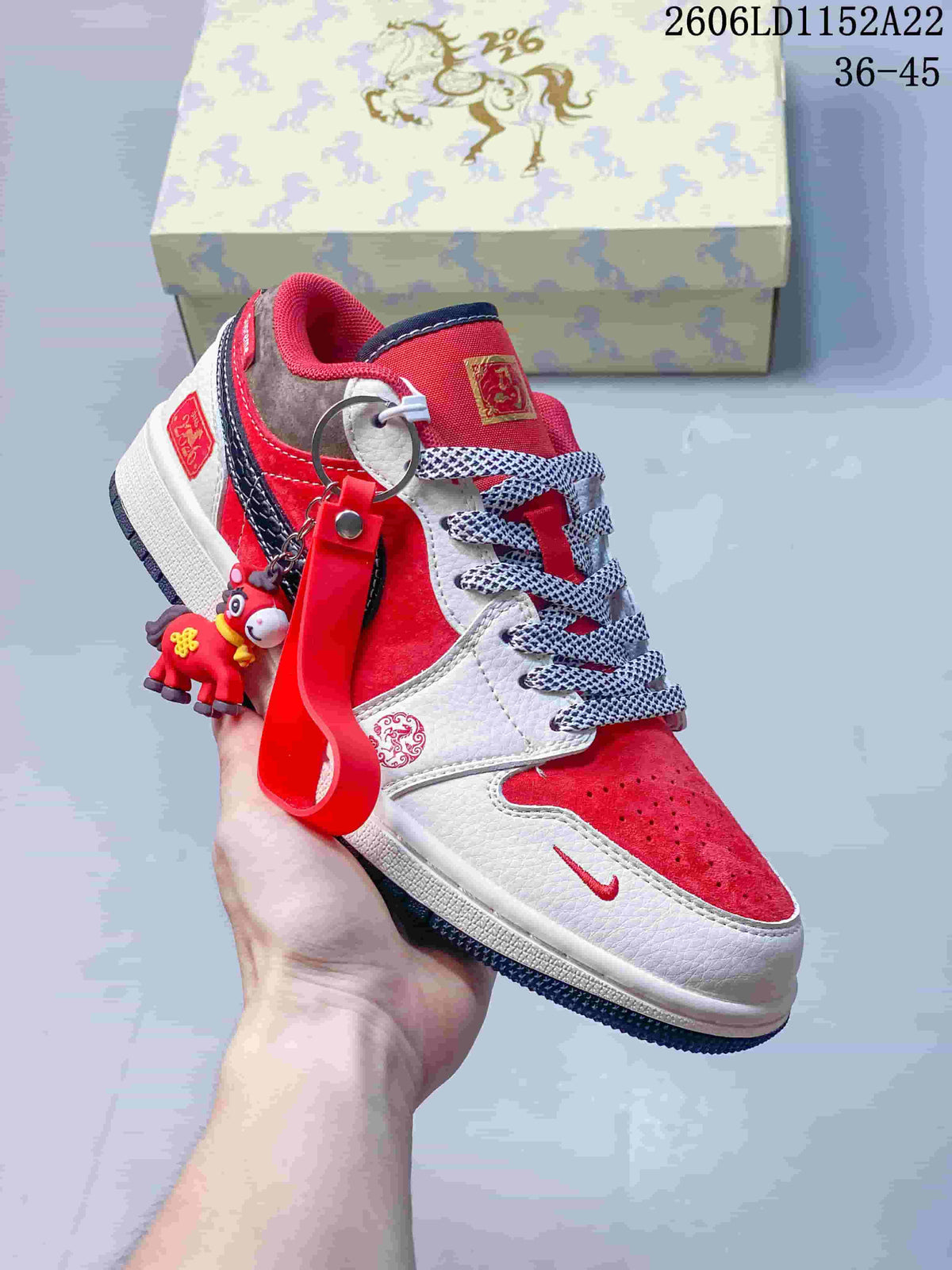 Angled view of a red and white Jordan sneaker with a dangling charm