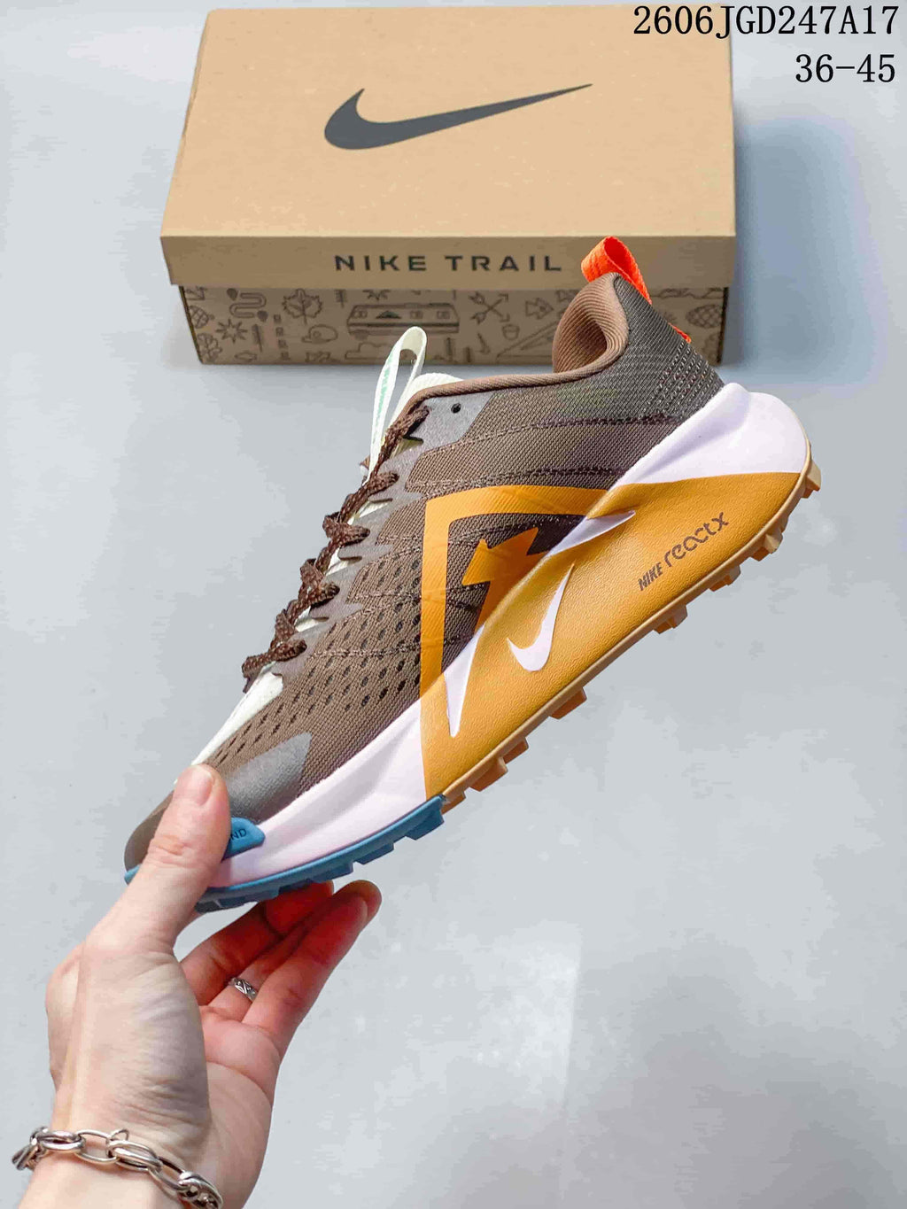 Side view of the brown trail shoe with orange accents