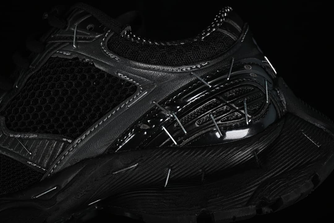 Close-up of the layered side panels, mesh, reflective-looking details, and sole.