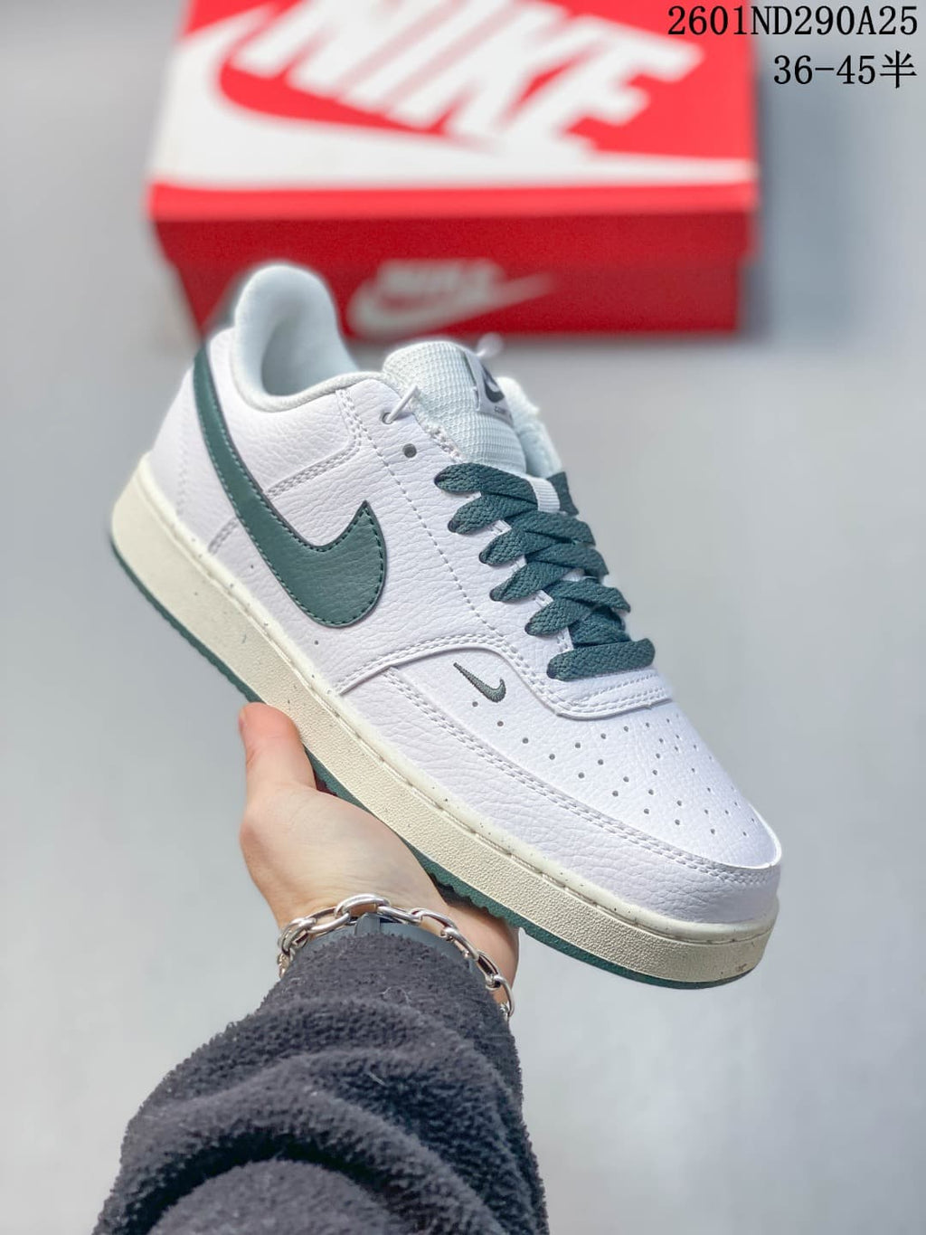 White low-top sneaker with dark green accents and contrasting laces