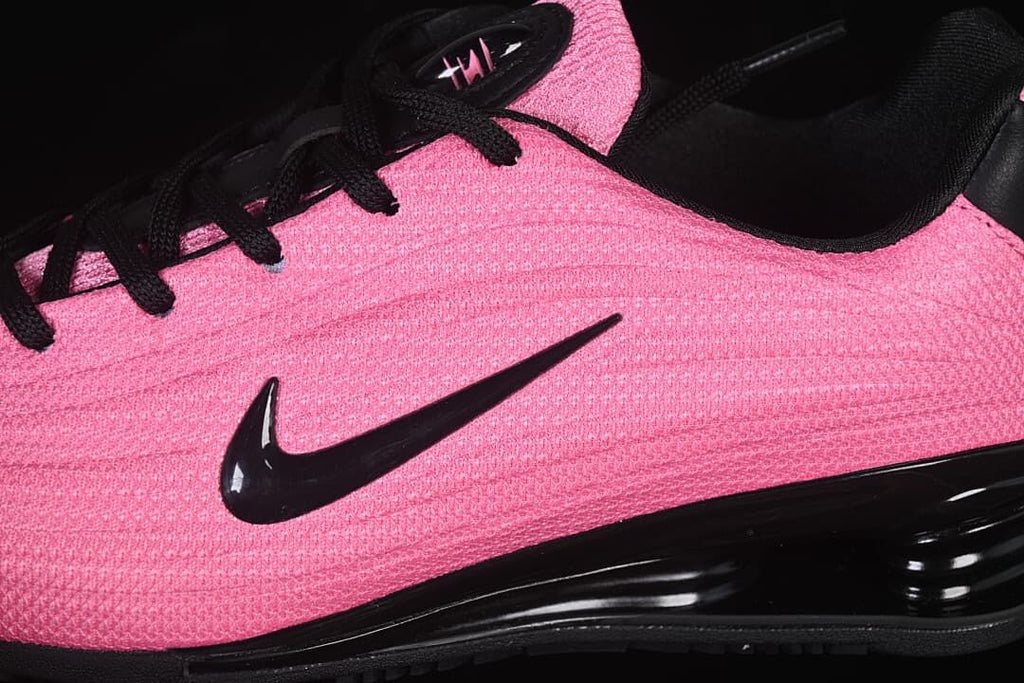 Close-up of the pink upper, black laces, and side Swoosh