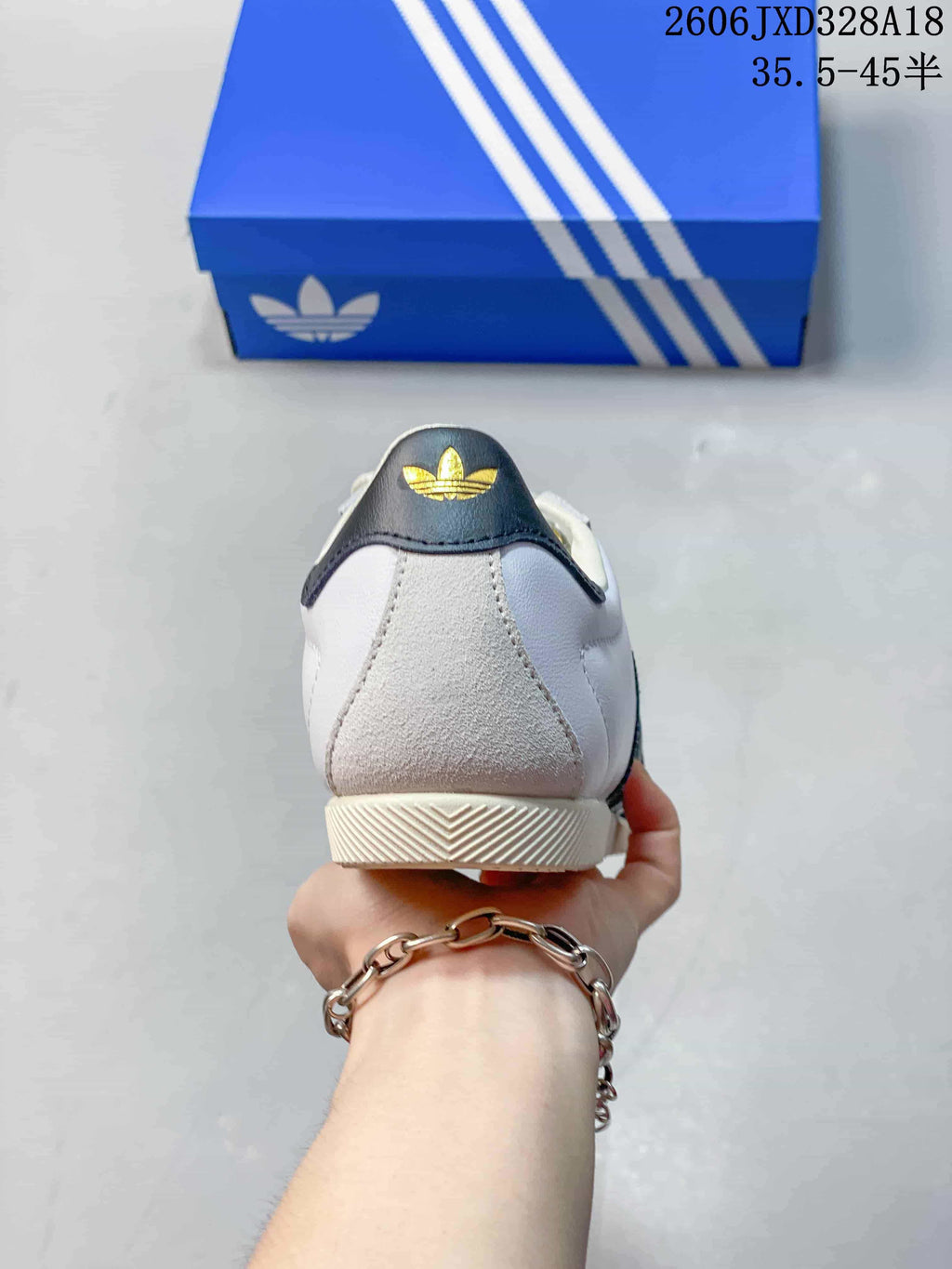 Rear view of the white sneaker with a dark heel tab and textured heel panel