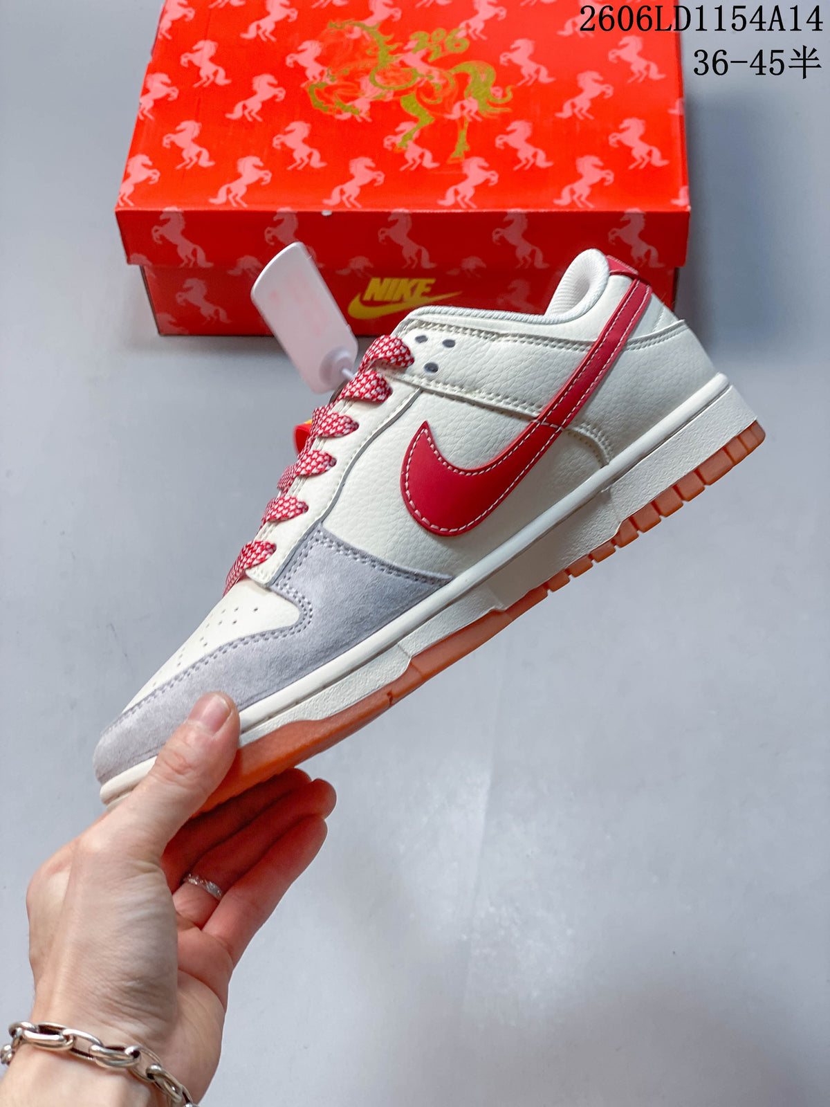 Side view of an off-white low-top sneaker with a red Swoosh, grey overlays, patterned panels, and orange outsole.