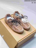 Pair of rose-beige Miu Miu and New Balance-style sneakers with mixed-color laces, shown on a box.