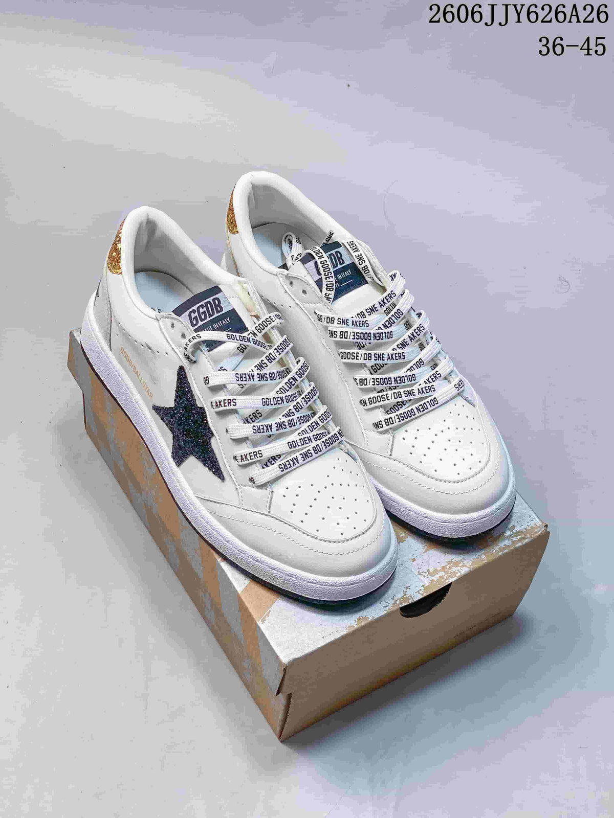 Pair of white low-top sneakers with dark star details, printed laces, and contrasting sole trims.