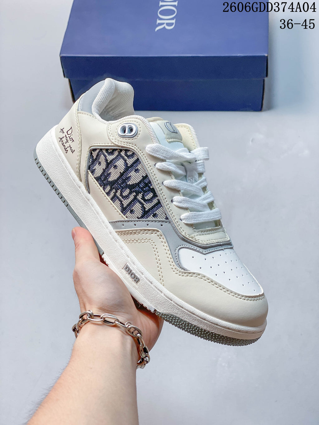 White low-top sneaker with a dark patterned side insert and gray trim.