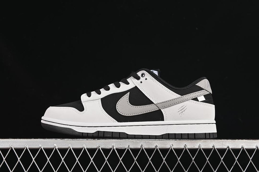Side profile of a black, white, and grey Nike SB Dunk Low sneaker