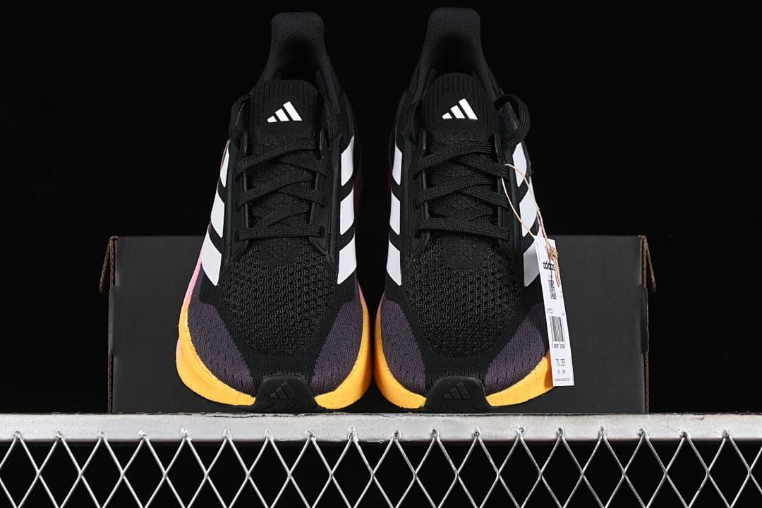 Front view of the pair showing black uppers, white stripes and yellow toe accents.