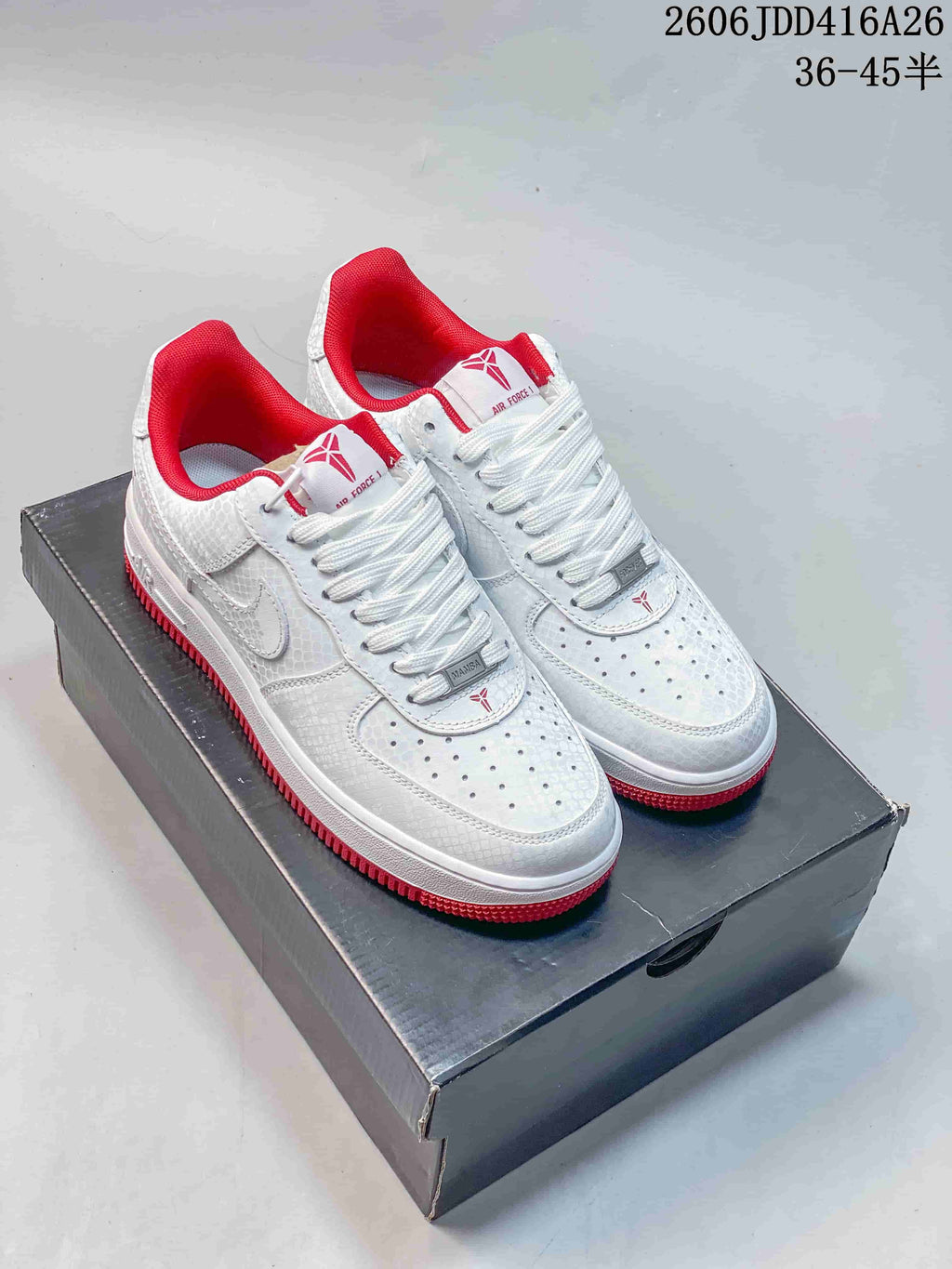 Pair of white low-top Nike Air Force 1 '07 sneakers with red lining and red outsole accents.