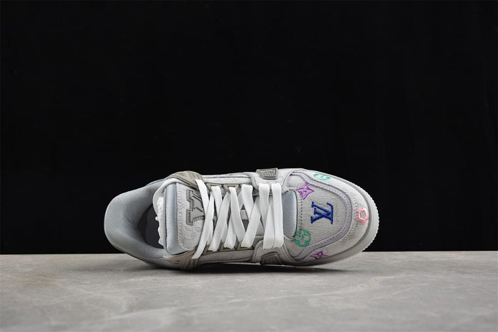 Top-down view of the sneaker with white laces and embroidered toe motifs