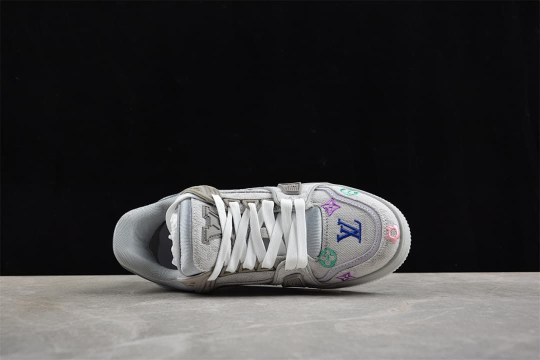 Top-down view of the sneaker with white laces and embroidered toe motifs