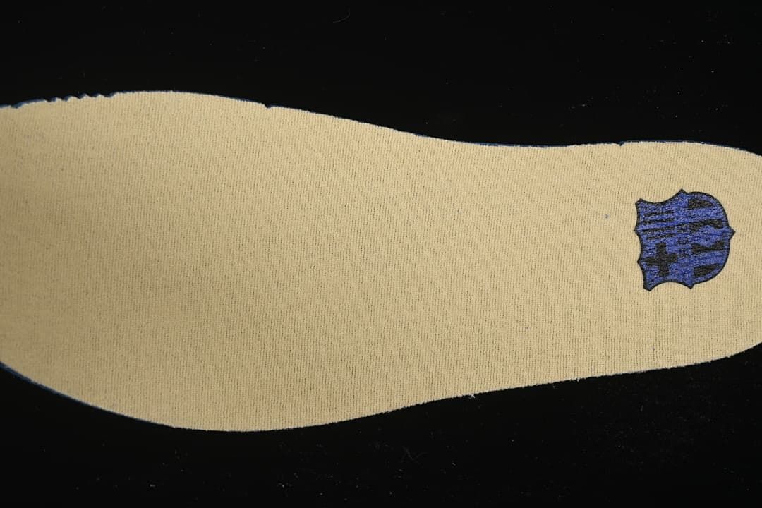 Close-up of a cream-colored shoe insert with a small graphic.