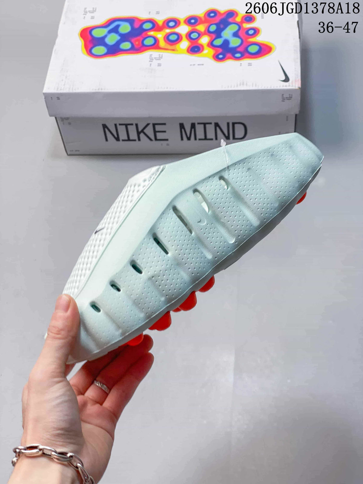 Side view of a Nike Mind slide showing perforated details and outsole elements