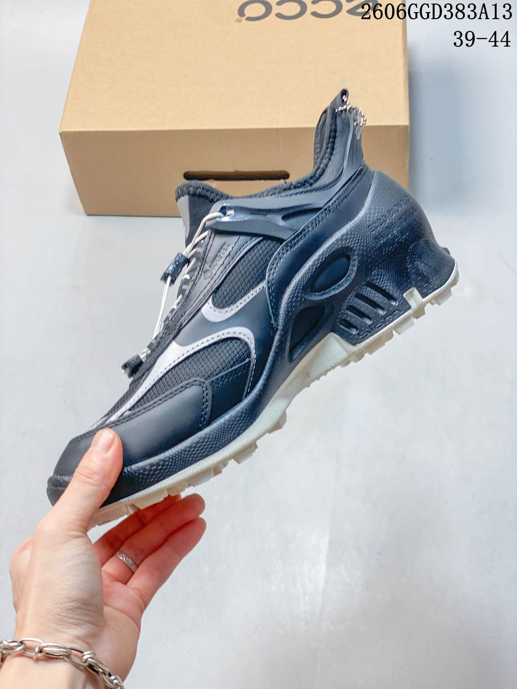Side view highlighting the navy and gray panels, mesh sections, and chunky sole.