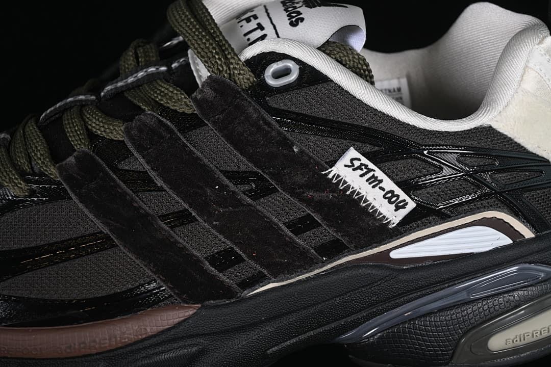 Close-up of the black upper, layered side panels, olive-toned laces and SFTM detail.