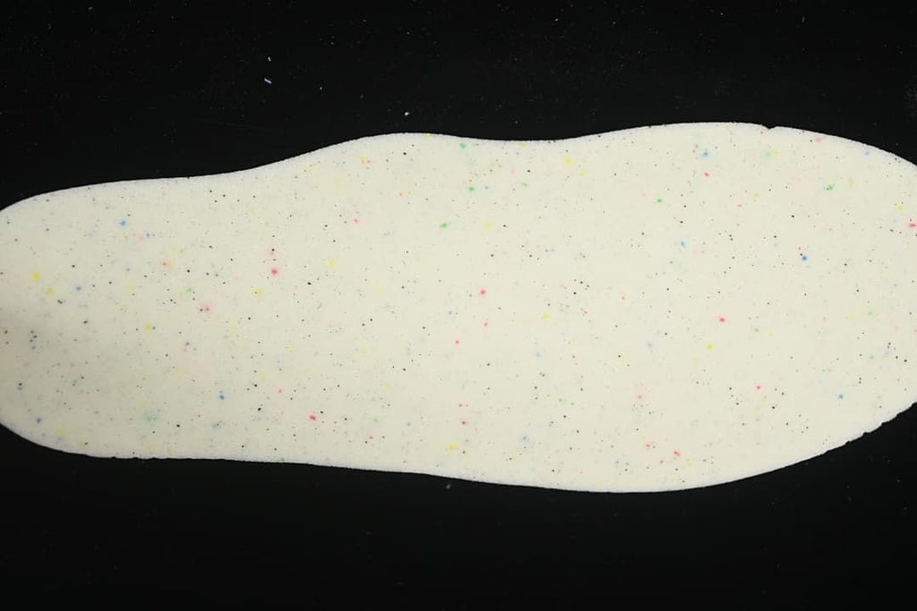 Close-up of a light-colored shoe insole with multicolored speckles