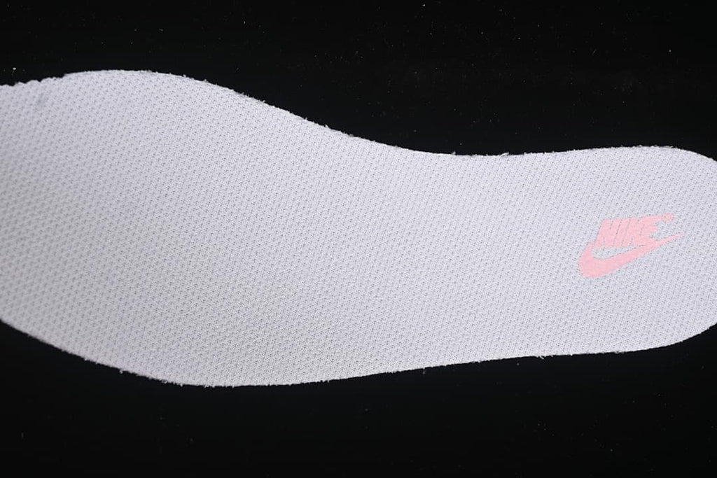 Close-up of a light-colored shoe insert with a pink Nike logo