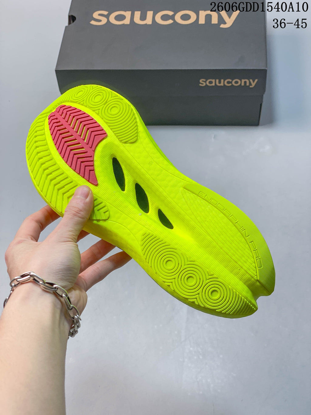 Saucony Endorphin Pro 5 shoe outsole with neon yellow tread and pink accent.