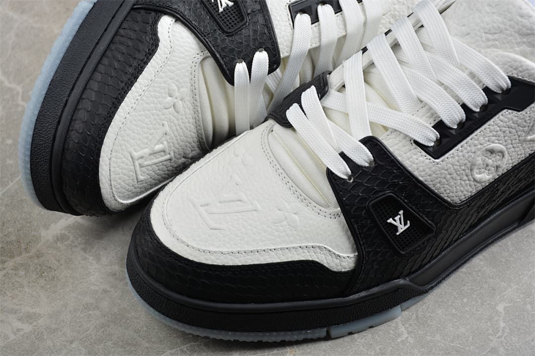 Close-up of the toe and side panels with embossed motifs and contrasting black trim.