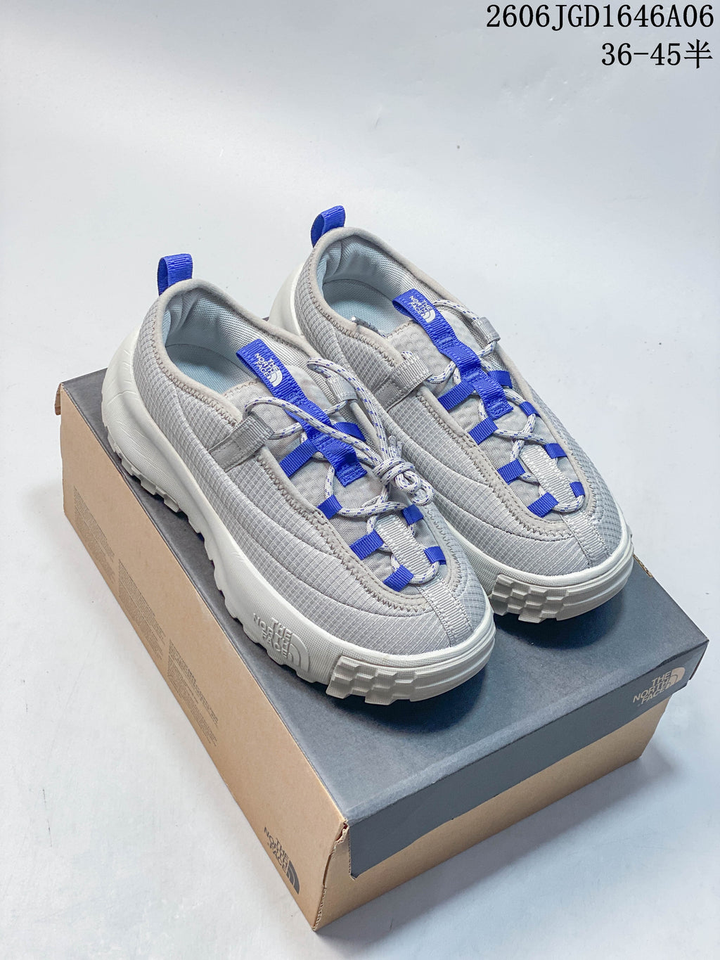 Pair of gray The North Face ThermoBall Traction Mule V shoes with blue accents on a box.