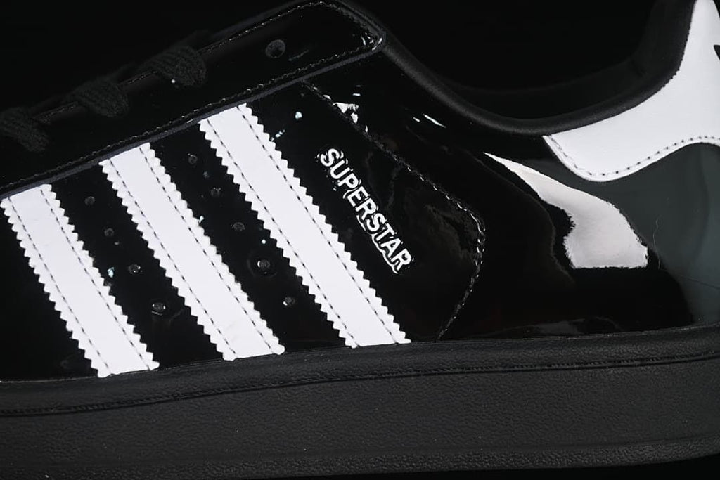Close-up of the black upper, white stripes and Superstar lettering