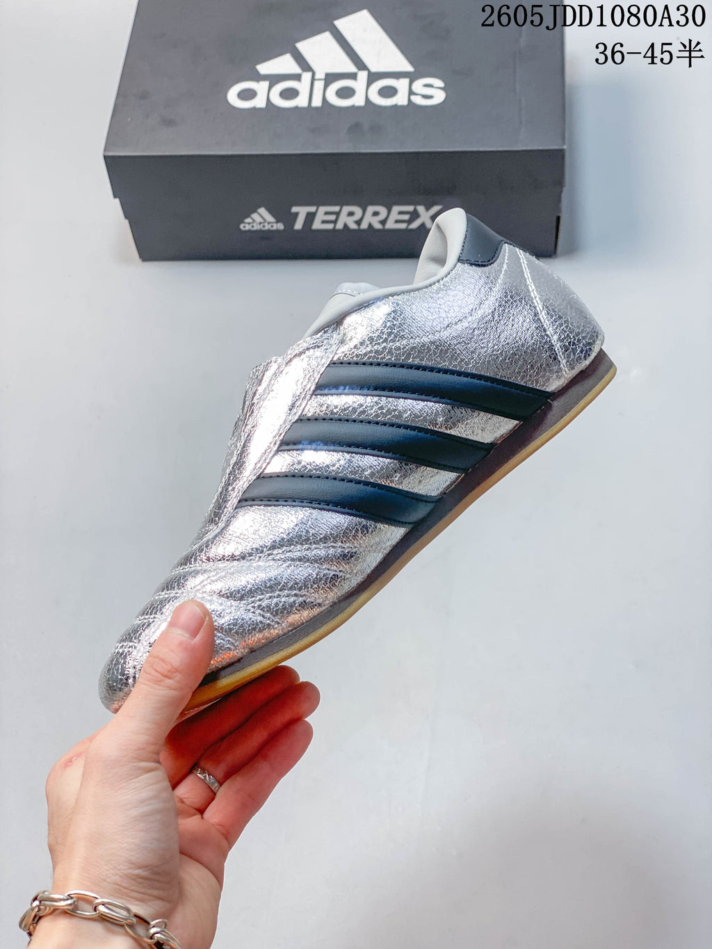 Side view highlighting the reflective silver finish and dark stripes