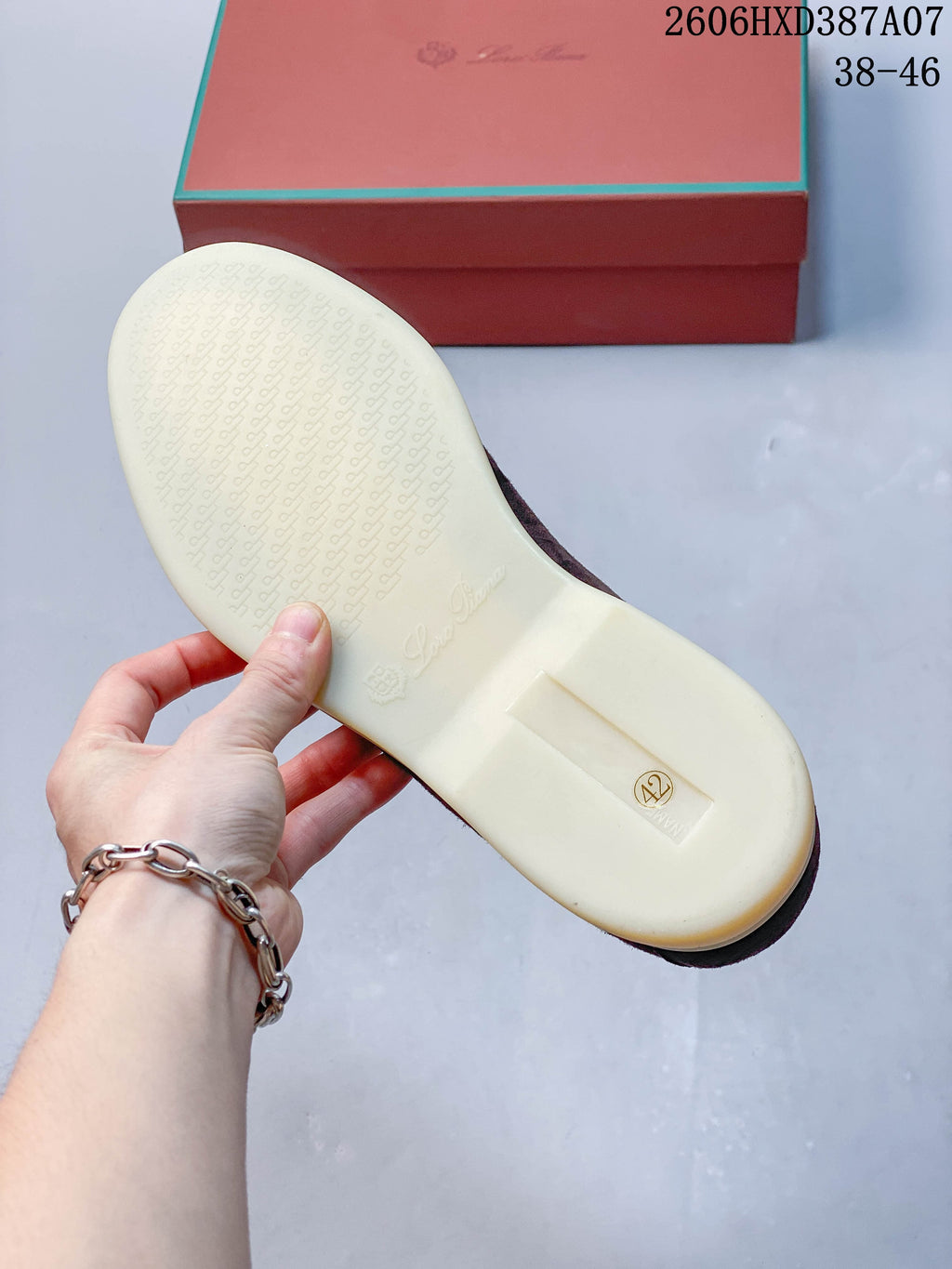 Underside of a loafer showing a light-colored sole and a size marking of 42.