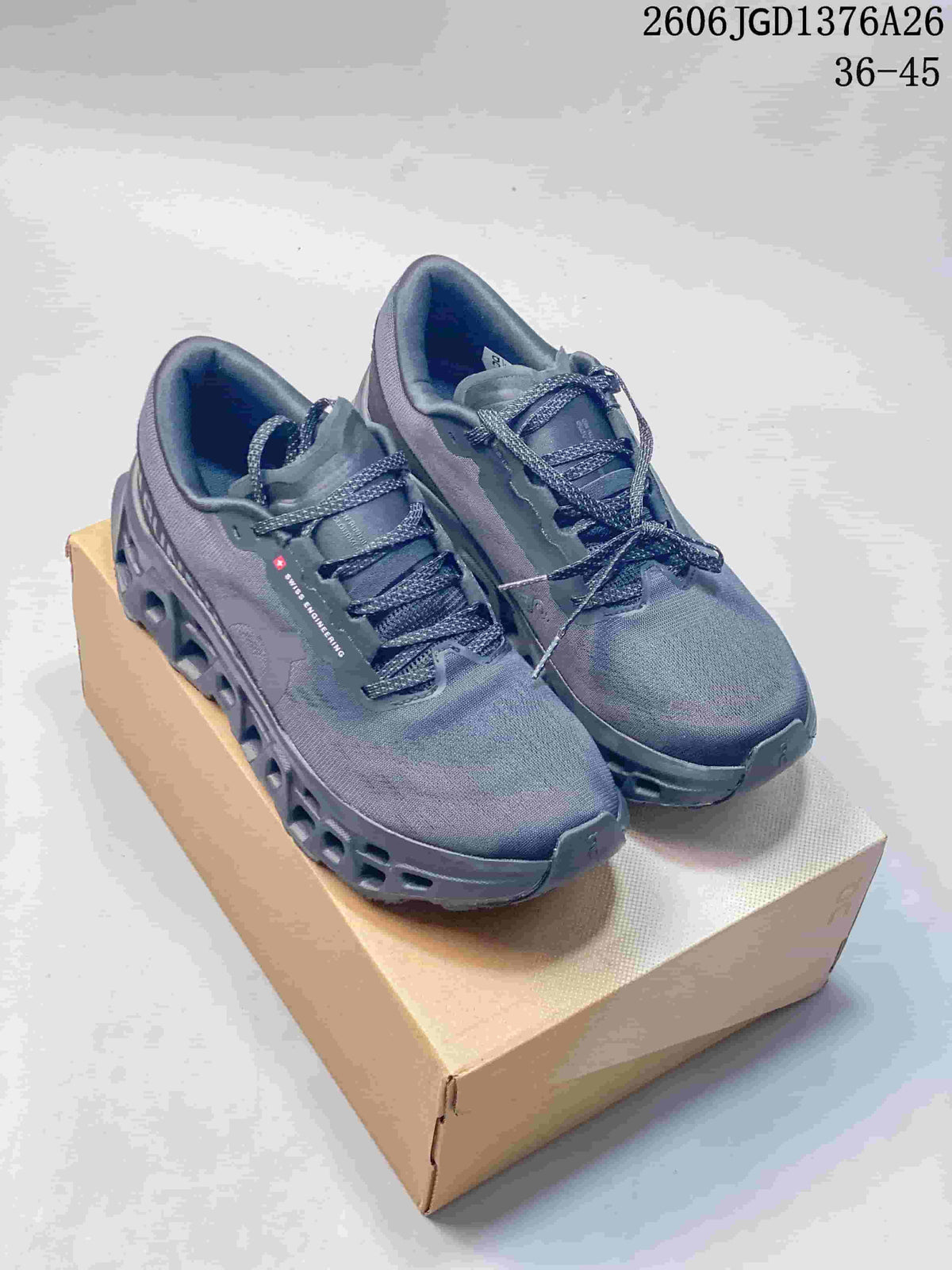 Pair of slate On Cloudmonster 3 shoes with dark laces and open-channel midsoles.