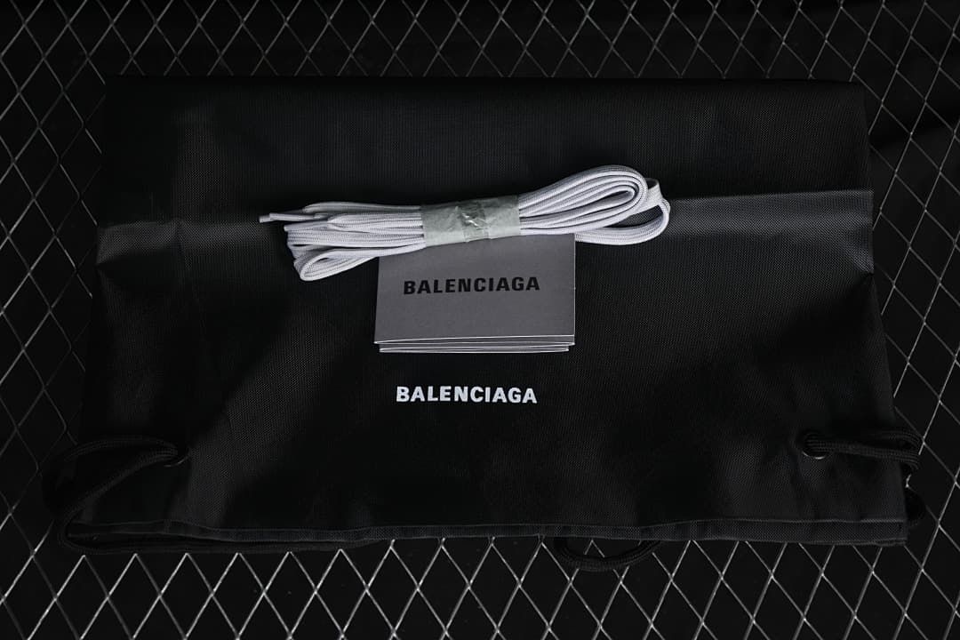 Shoestrings and branded dust bag shown with the sneaker