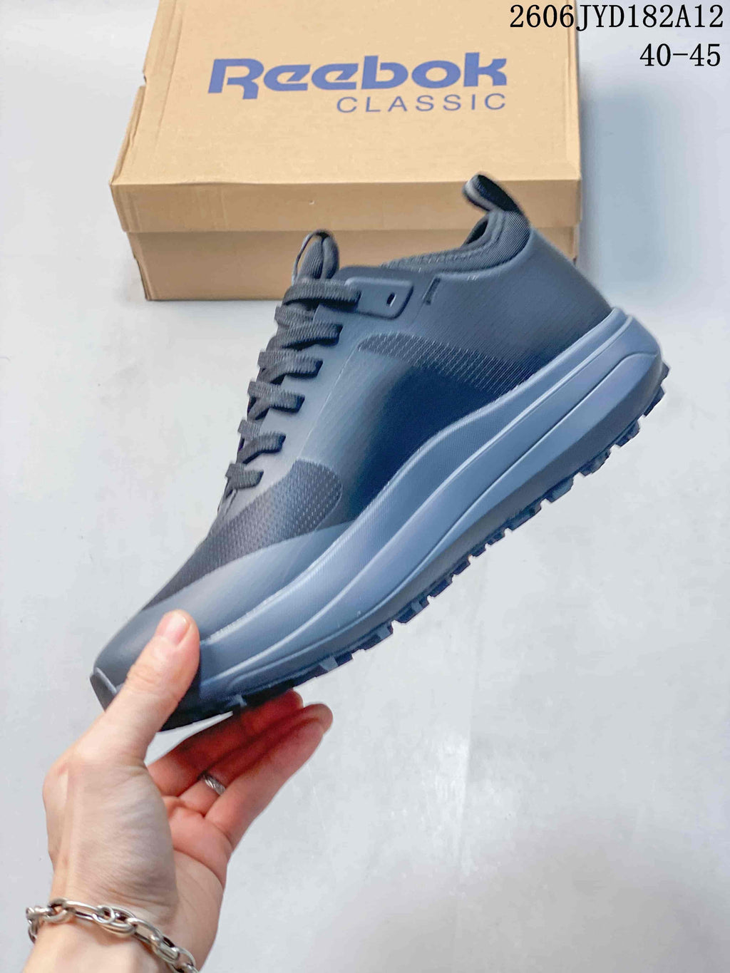 Side view of the grey low-top sneaker with laces and a lugged outsole