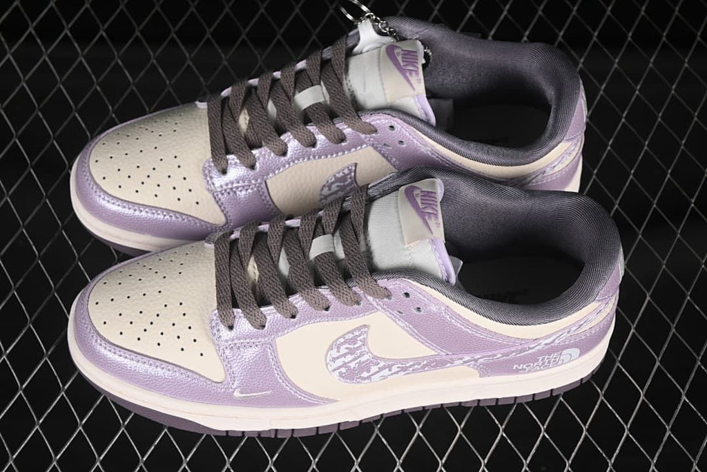 Pair of cream and lavender-purple low-top sneakers shown from above, with patterned swooshes and dark laces