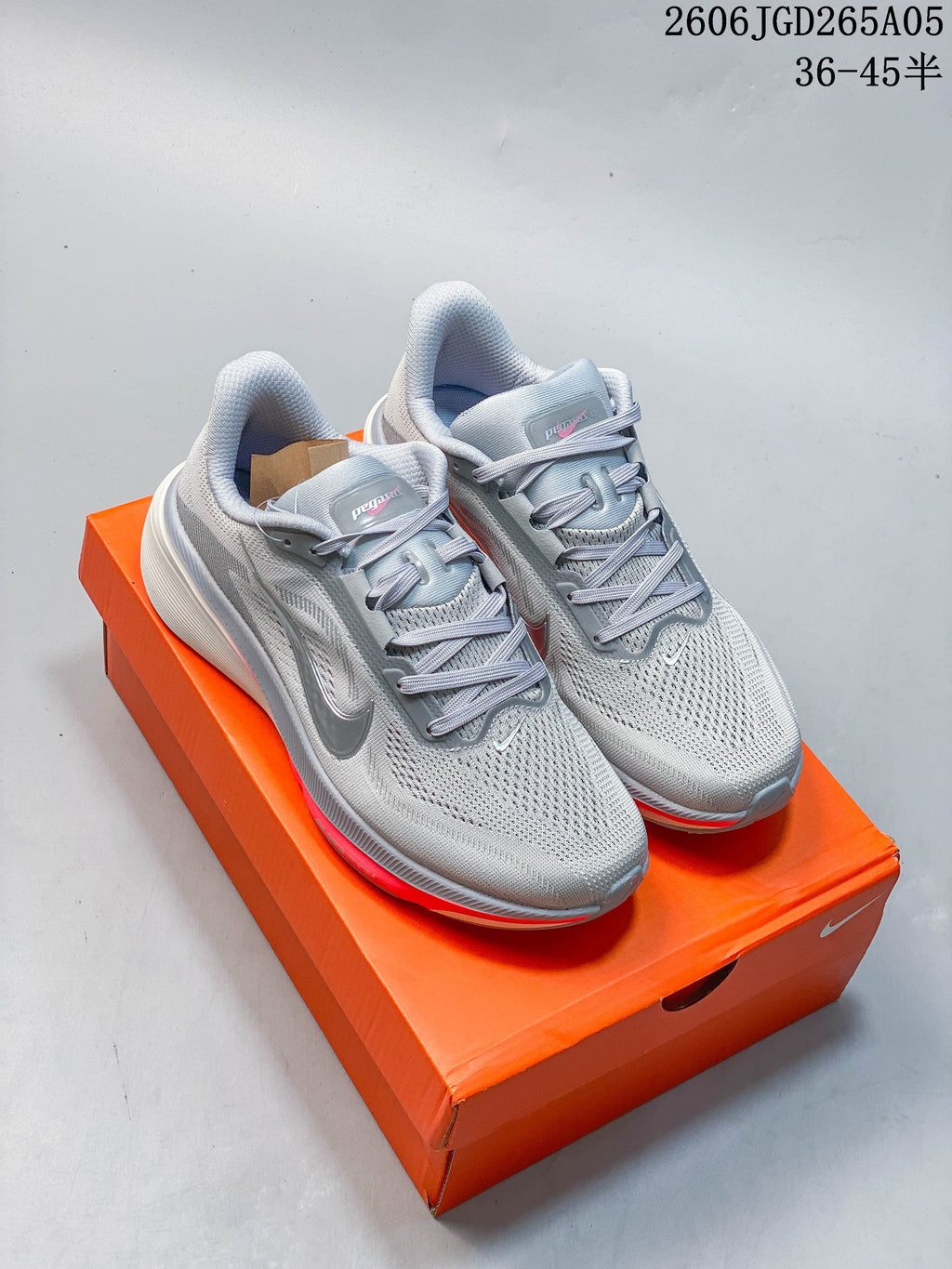 Three Nike Pegasus 42 shoes shown from the side in white with dark, green, and coral accents.