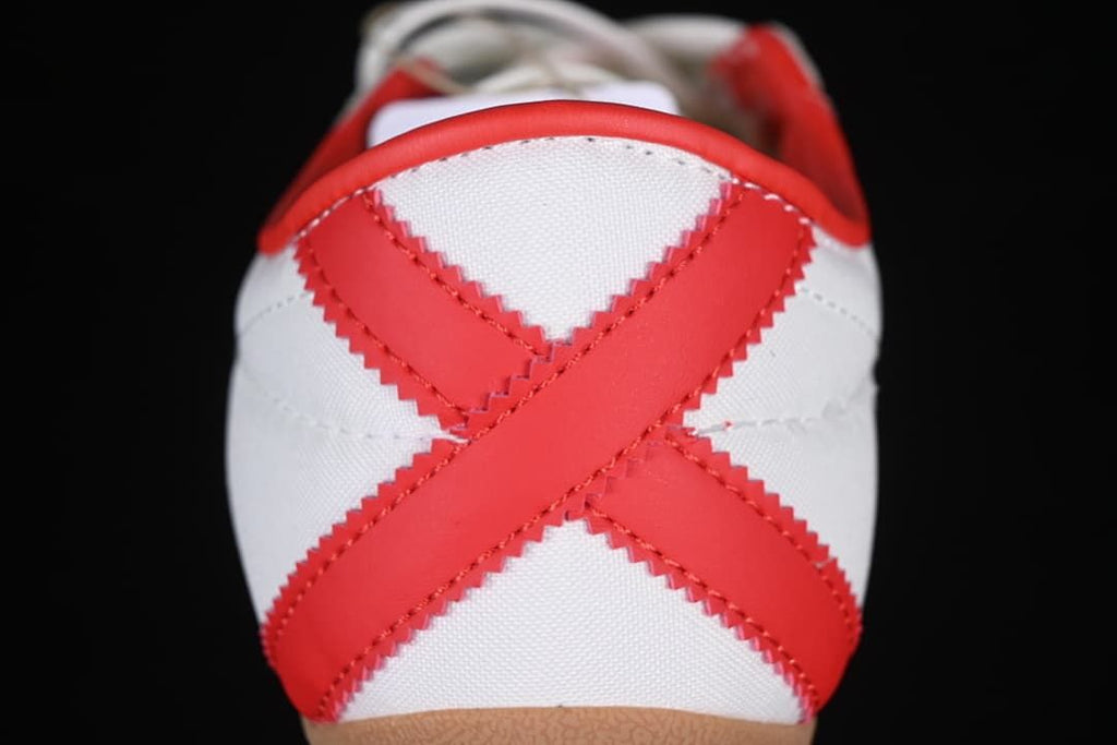 Rear view of the sneaker with crossed red heel overlays