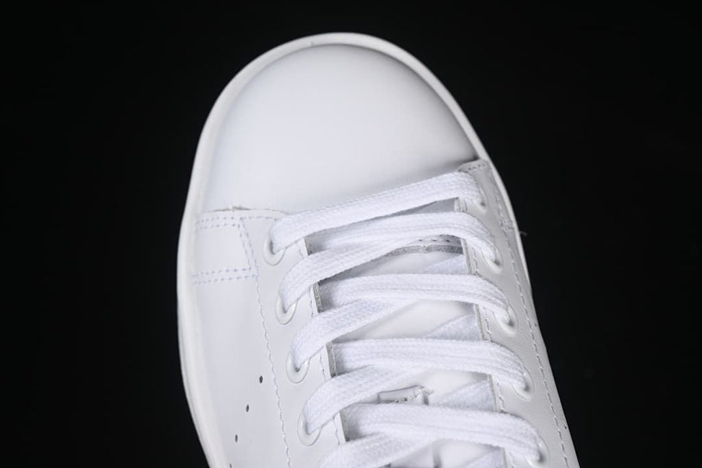 Top-down close-up of the white sneaker's laces and toe
