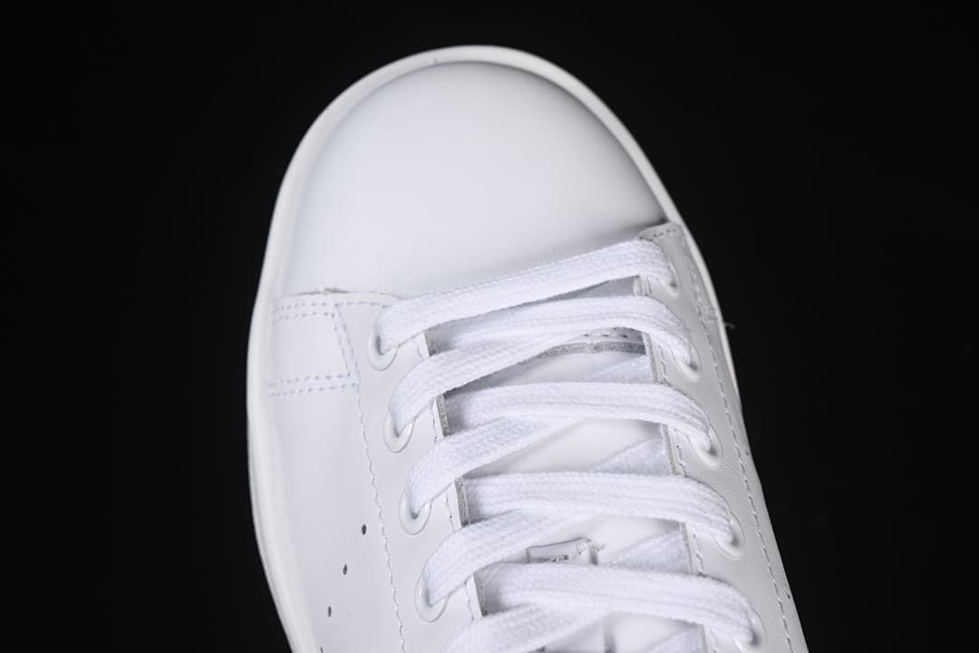 Top-down close-up of the white sneaker's laces and toe