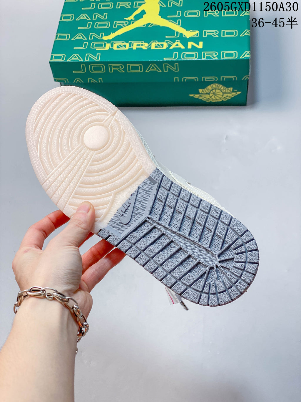 Close-up of the sneaker outsole, with an off-white forefoot section and gray heel section.