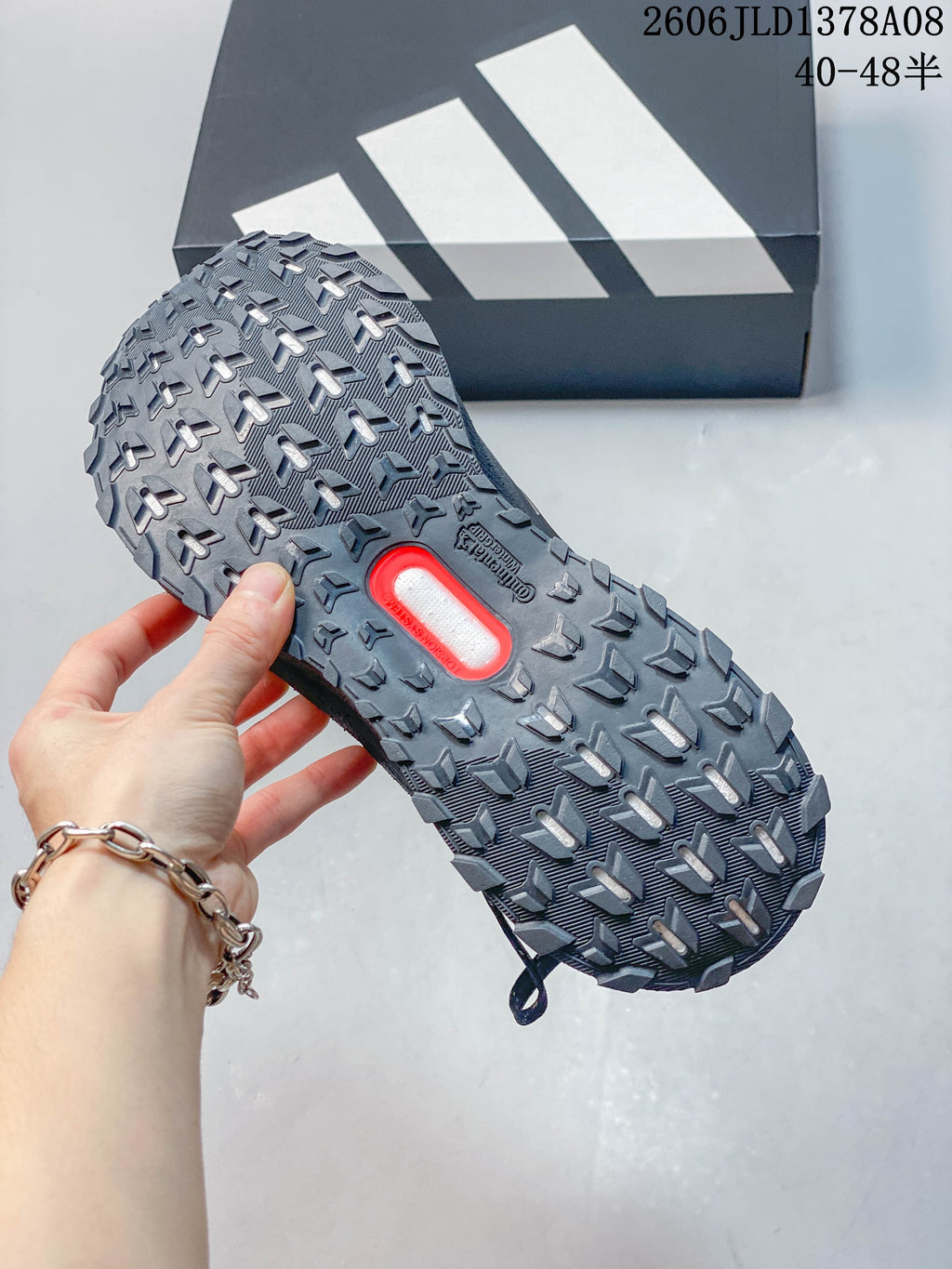 Close-up of the grey shoe's lugged outsole and central insert