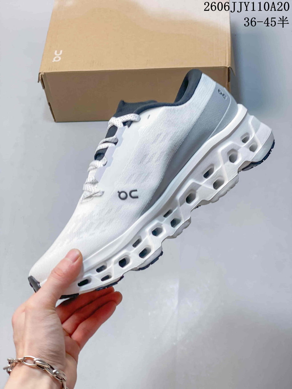 Side view highlighting the white upper and cutout sole of the On Cloudmonster 3