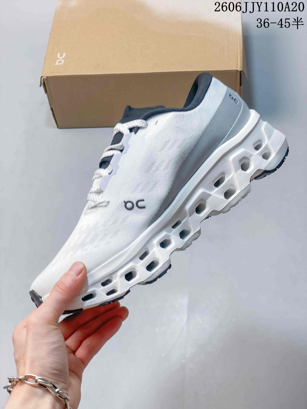 Side view highlighting the white upper and cutout sole of the On Cloudmonster 3