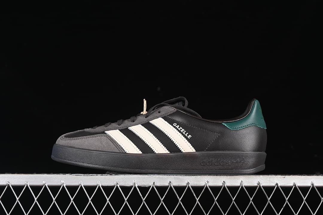 Side profile of the black adidas Gazelle Indoor with grey overlays, off-white stripes, and teal-green heel detail