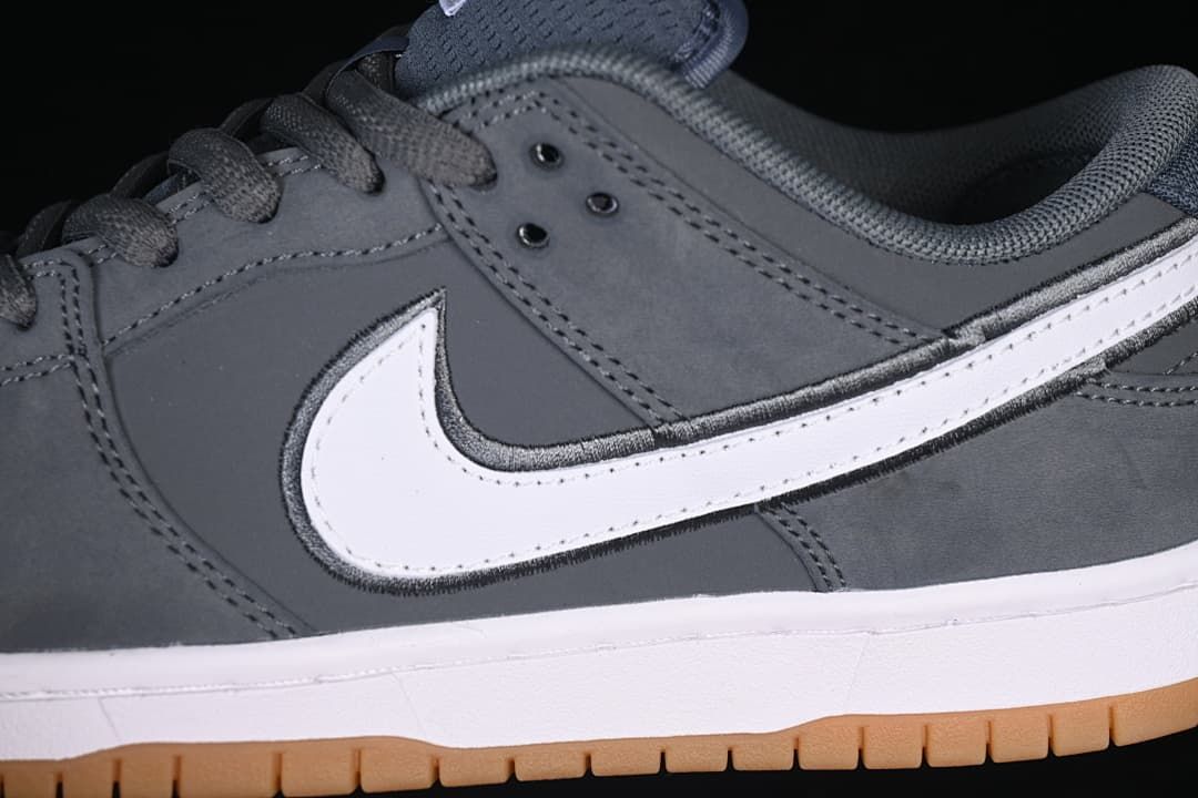 Close-up of the white side panel against the gray upper, with gray laces and padded collar.