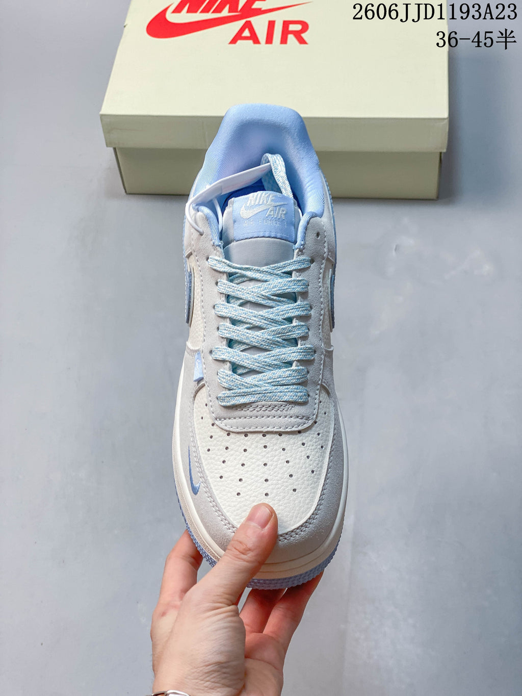 Top view of a white and pale blue Nike Air Force 1 sneaker with blue laces