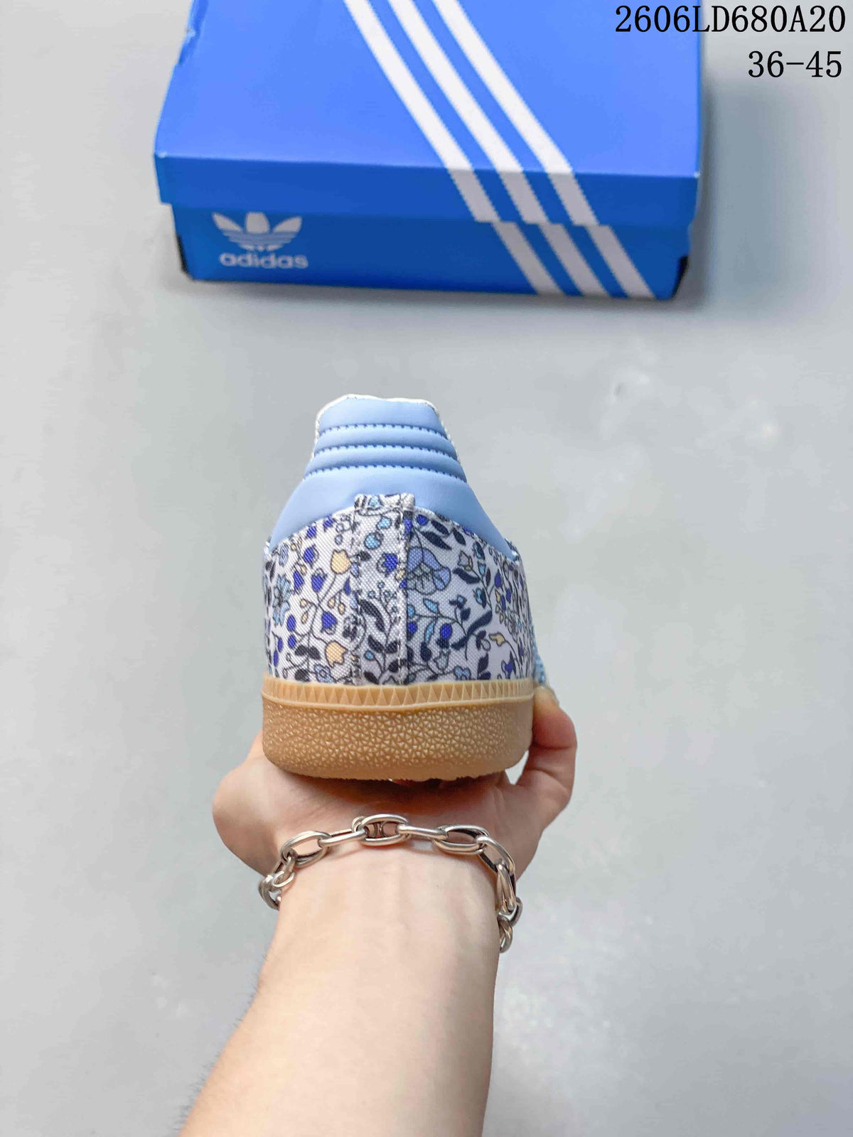 Rear view of the floral-print sneaker with a light blue heel detail and gum-colored sole.