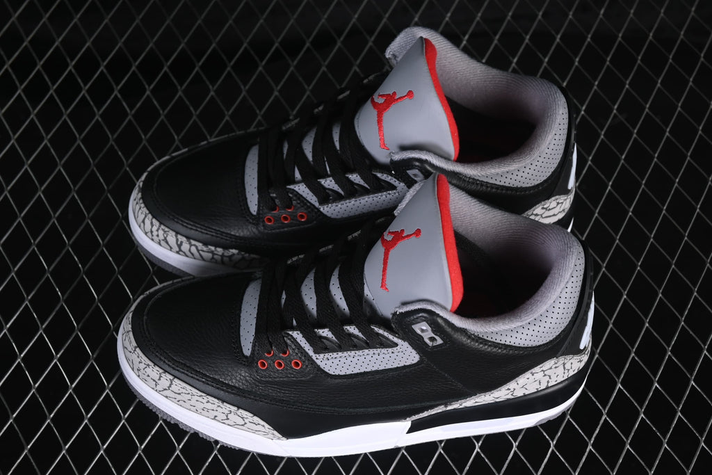 Angled top view of the pair highlighting black uppers and cement-pattern overlays