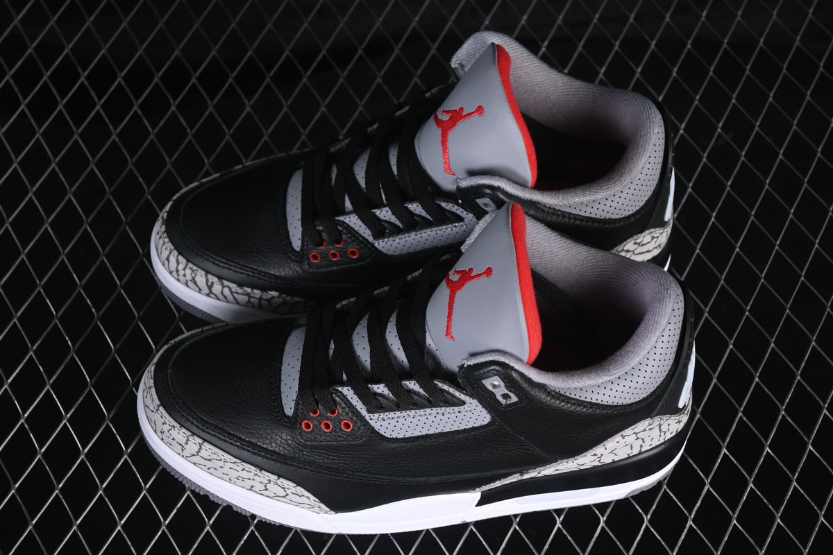 Angled top view of the pair highlighting black uppers and cement-pattern overlays