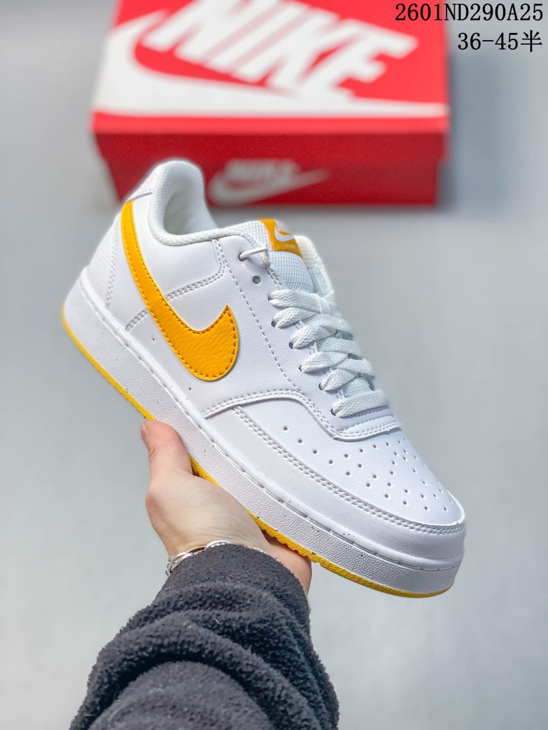 White low-top sneaker with yellow accents and perforated toe