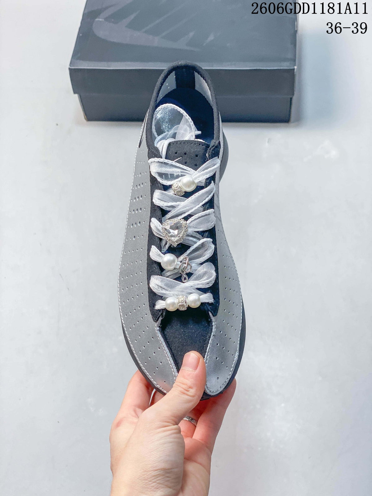 Top view of the sneaker with white ribbon-style laces and decorative accents.