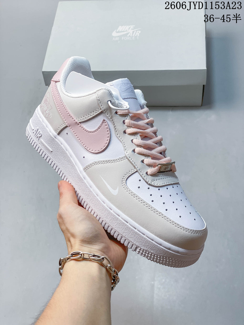 Angled side view showing the white and pale pink sneaker design