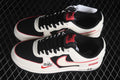 Pair of Nike Air Force 1 Low sneakers showing the white, black and red color scheme, black laces and side branding.